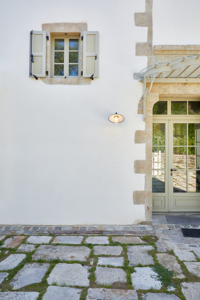 applique fermob allumée dans la cour en dalle de pierre naturelle avec joint en herve