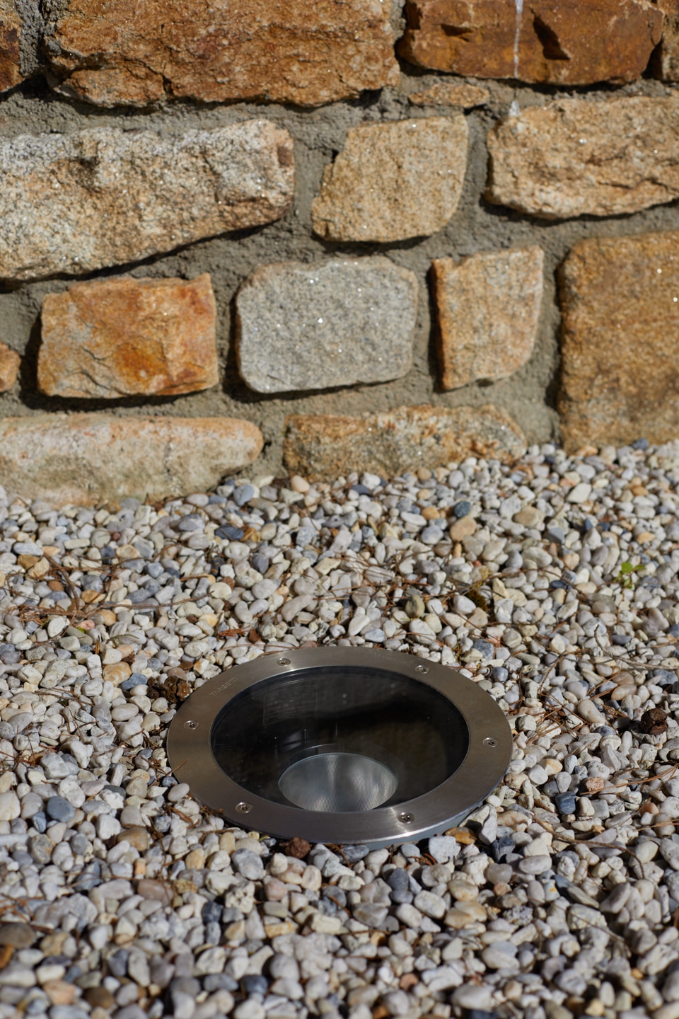 spot encastré dans gravillons blancs devant un muret