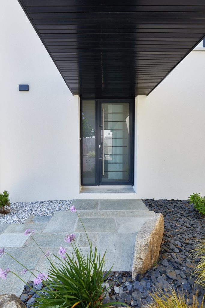 entrée de maison avec massif minéral et dalle de luzerne