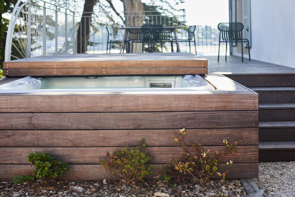 spa intégré dans la terrasse avec table pour déjeuner surplombant la mer