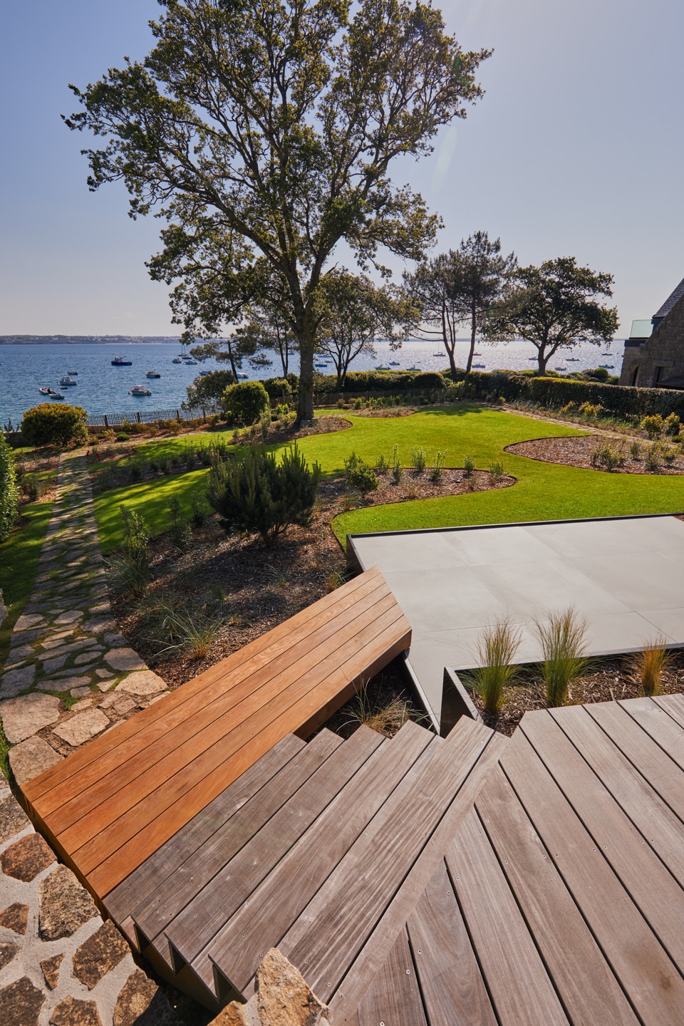 escalier eb bois descendant sur une terrasse en grès ceram avec une passerelle en bois