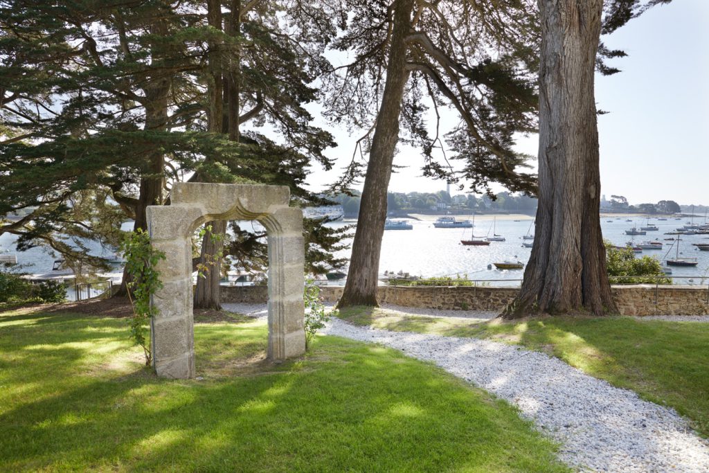 arche en granite servant de support pour des rosiers