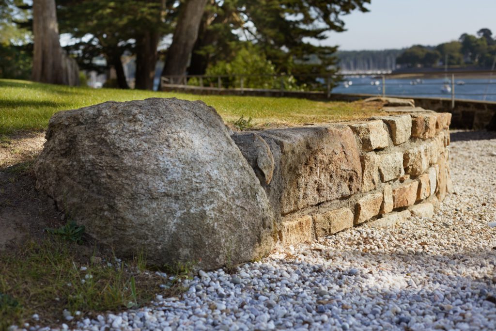 muret en pierre taillé avec roche intégrée devant le port de sainte marine