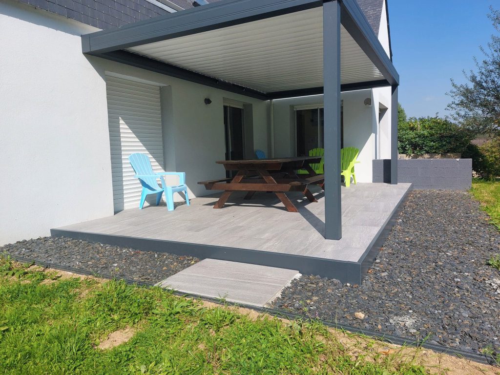 Pergola en aluminium devant maison sur une terrasse en grès ceram