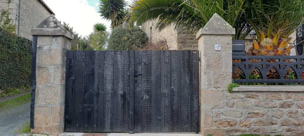 portail en bois brulé entre deux piliers