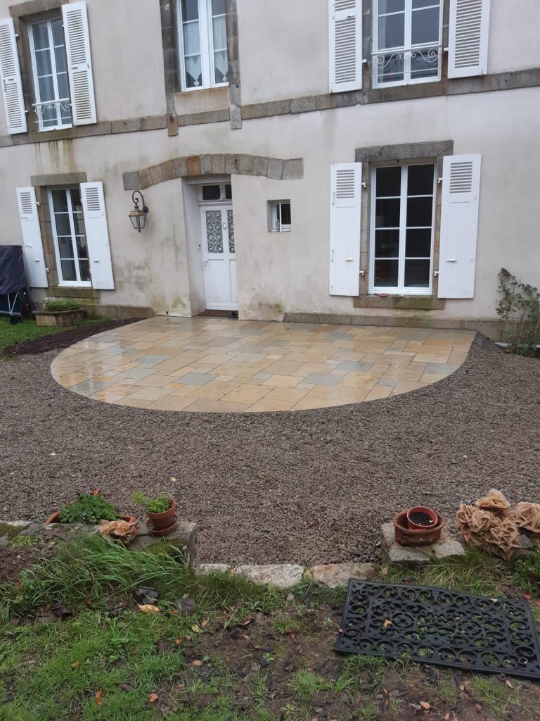 Terrasse en dalle de luzerne devant maison ancienne