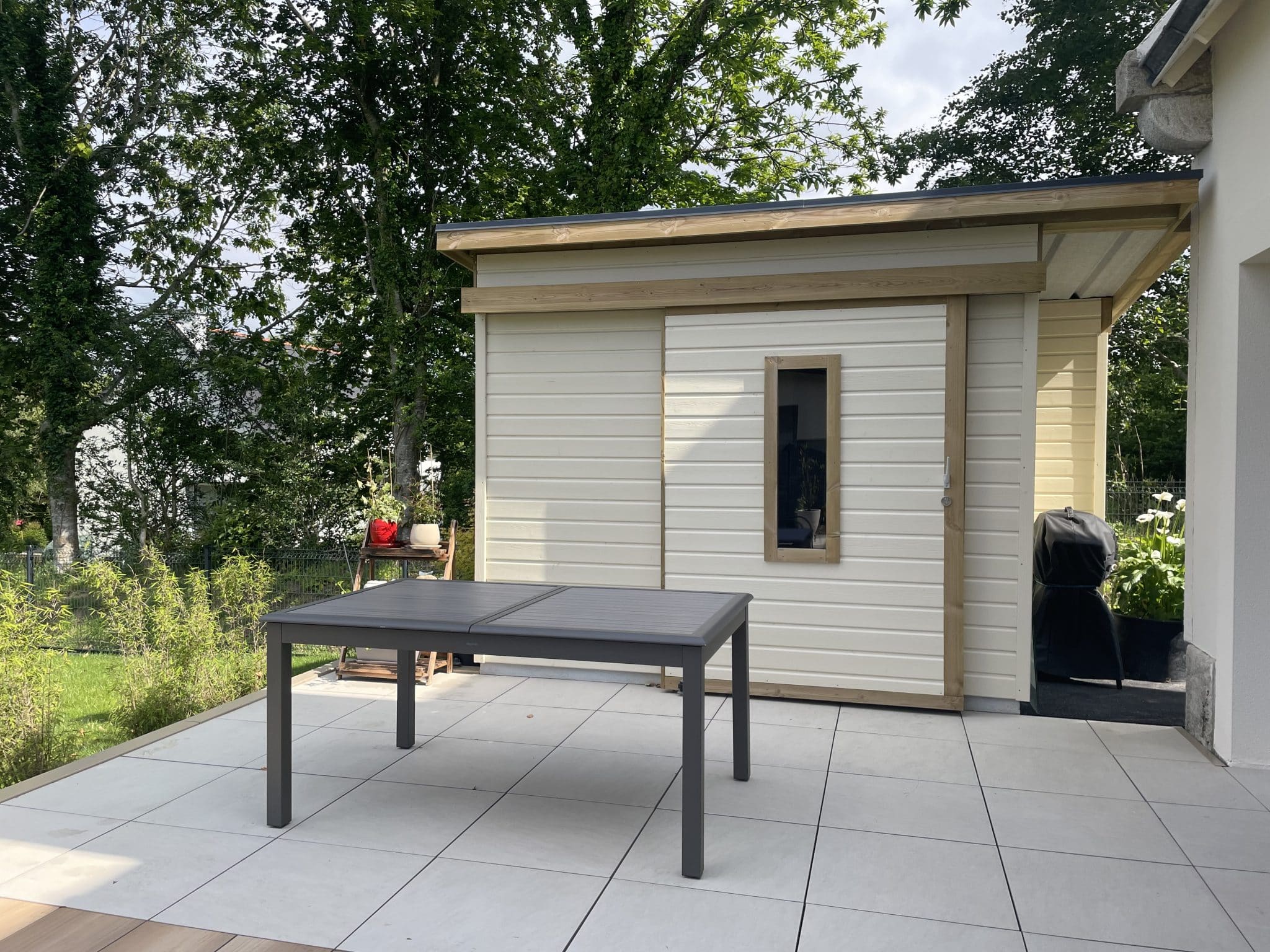 Abris en bois laqué blanc sur-mesure avec une porte fenêtre et auvent