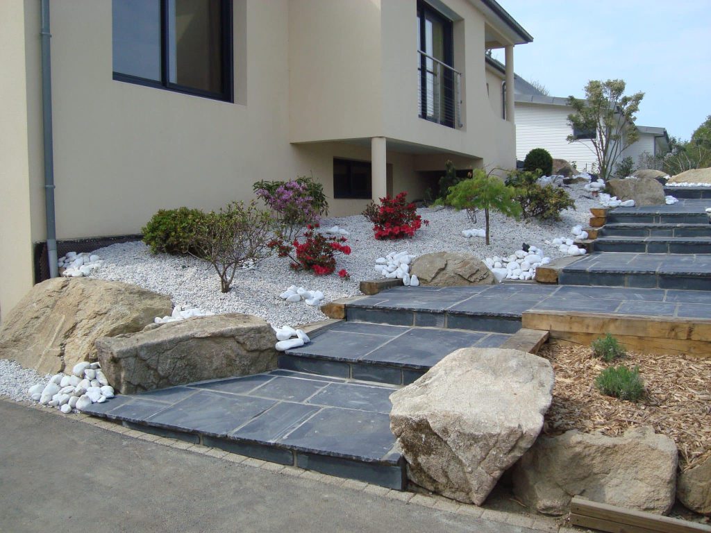 escalier en dalle d'ardoise avec des roches autour et des massifs minérals