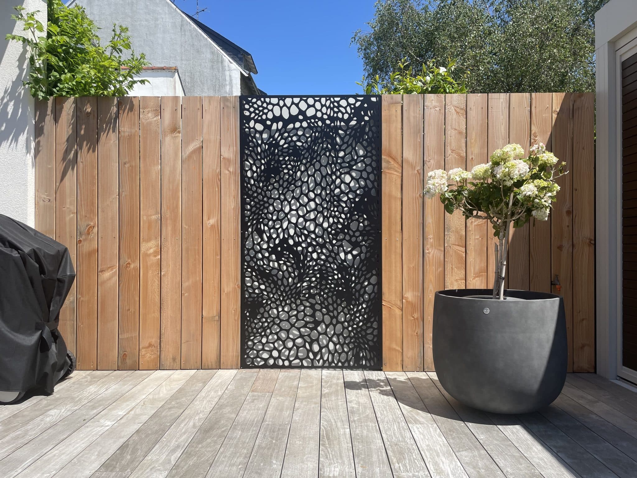 habillage de mur en bois et grille en luminium avec motif
