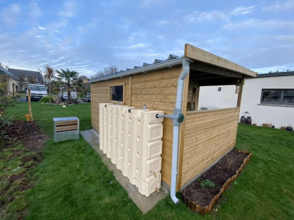 Abri en bois avec un bac de récupération d'eau relié à une goutière