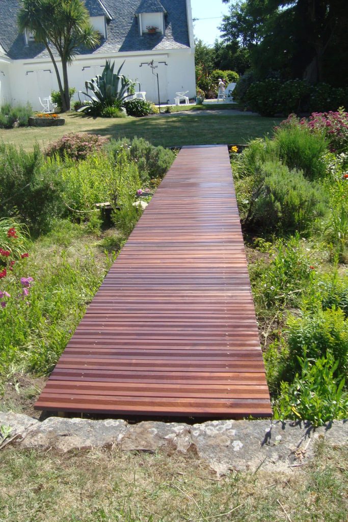 ponton en bois exotique au-dessus d'un massif de vivaces