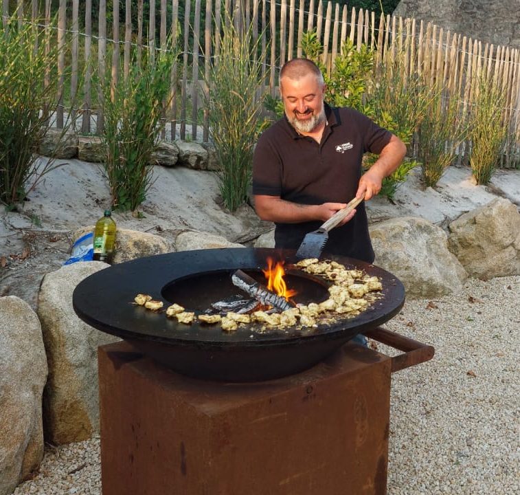 Christophe, salarié Kerne Elagage, nous prépare des morceaux de poulet, précédemment marinés, sur le brasero OFYR lors d'une soirée entreprise.